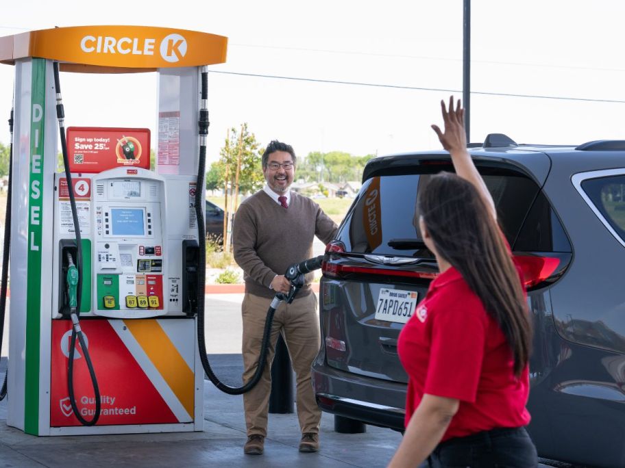 person waving at man getting gas at circle k