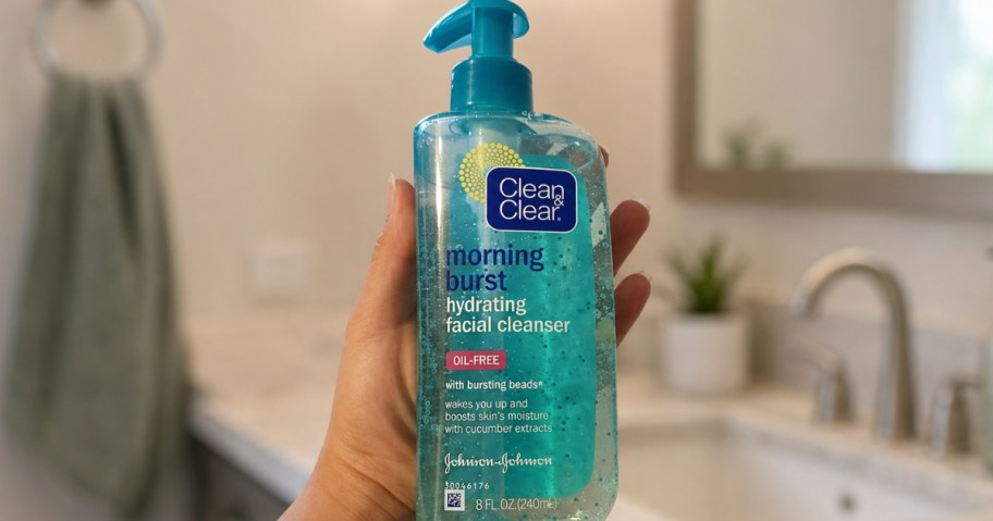 hand holding a bottle of Clean & Clear Facial Cleanser