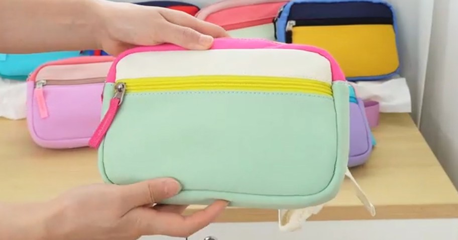 hands holding a colorblock belt bag