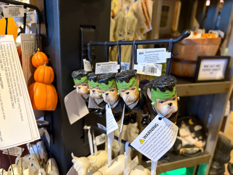 A display of small figurines resembling Frankenstein heads, hanging on a rack.
