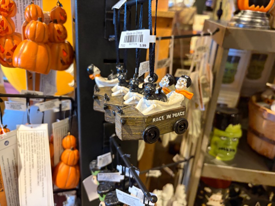 Decorative Halloween ornament featuring ghostly figures in a cart with the text "RACE IN PEACE."