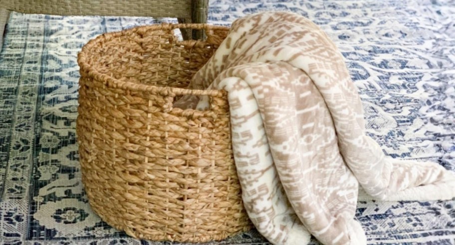 an eddie bauer throw blanket spilling out of a wicker basket