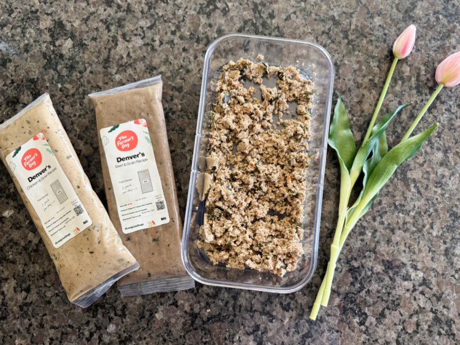 a bin of dog food next to two packs and two flowers