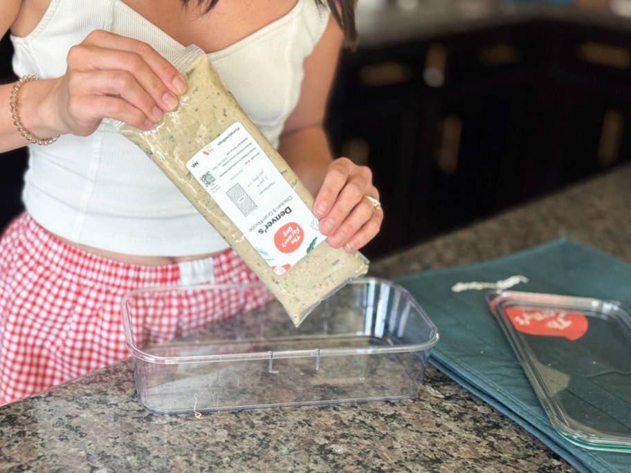 woman squeezing dog food into tray