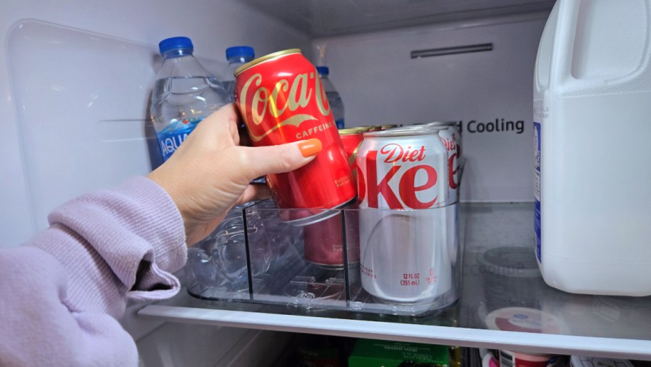 hand pulling a can of coke out of a fridge drink organizer