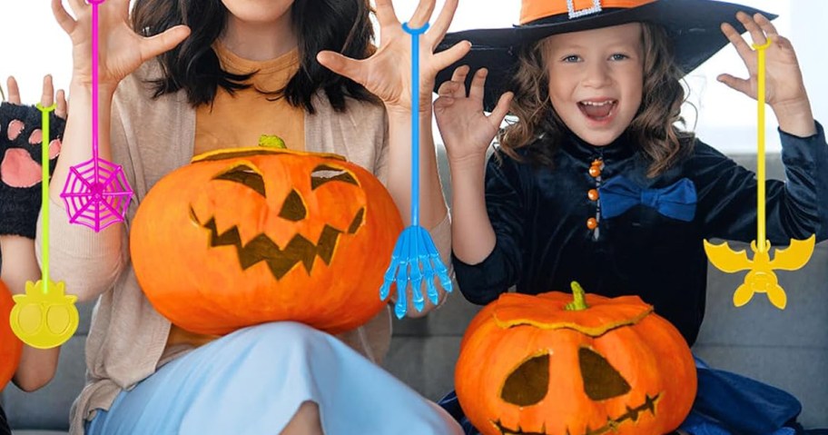 kids holding halloween sticky hand toys