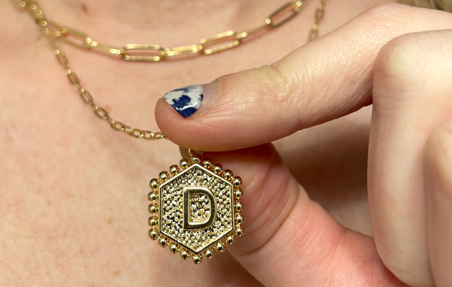 holding initial necklace 