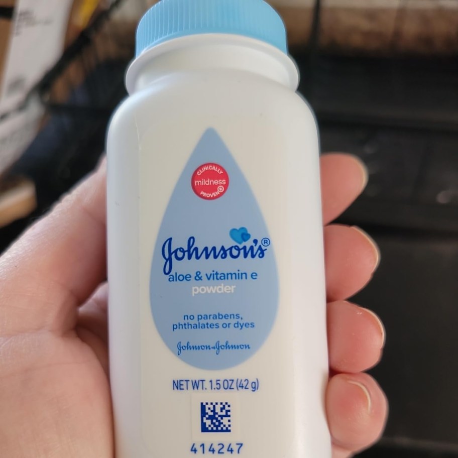 holding a trial size bottle of baby powder