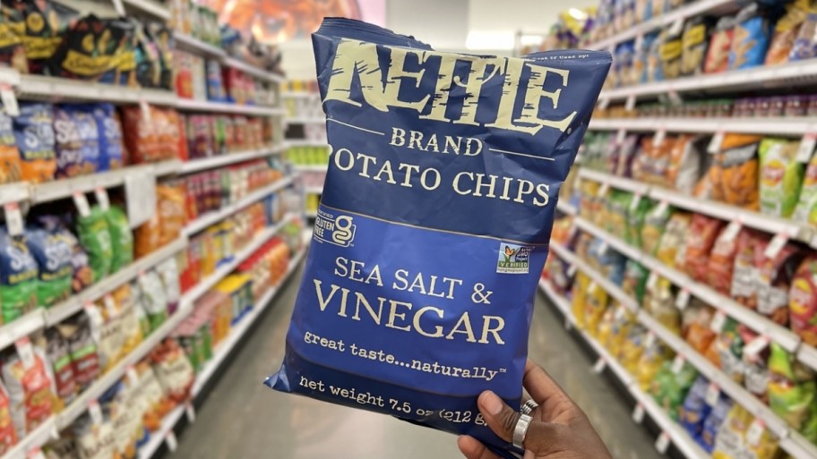 womans hand holding a bag of kettle chips