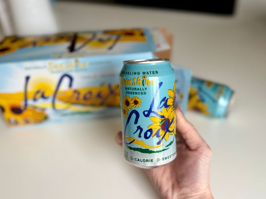 holding a can of LaCroix in front of the case on a countertop