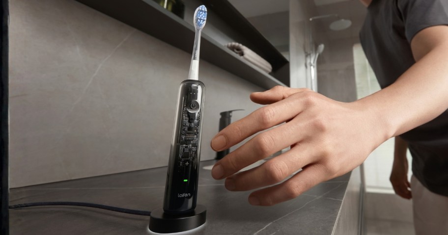 hand reaching for an electric toothbrush