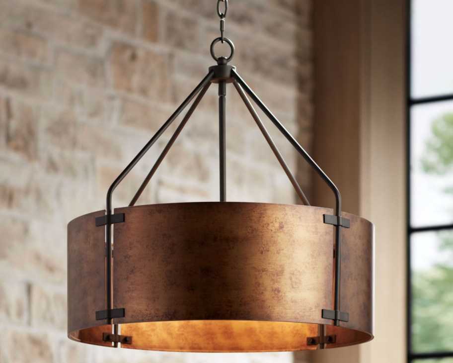 brass metal drum light hanging from ceiling