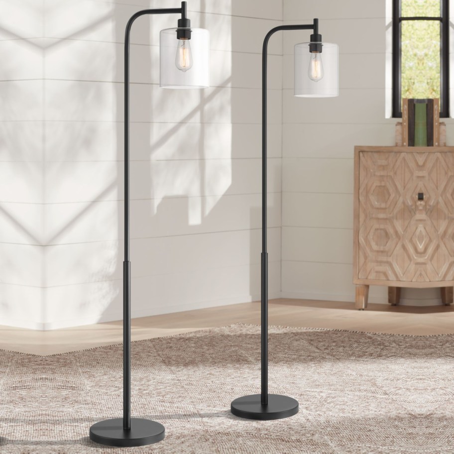two tall black floor lamps with single bulb
