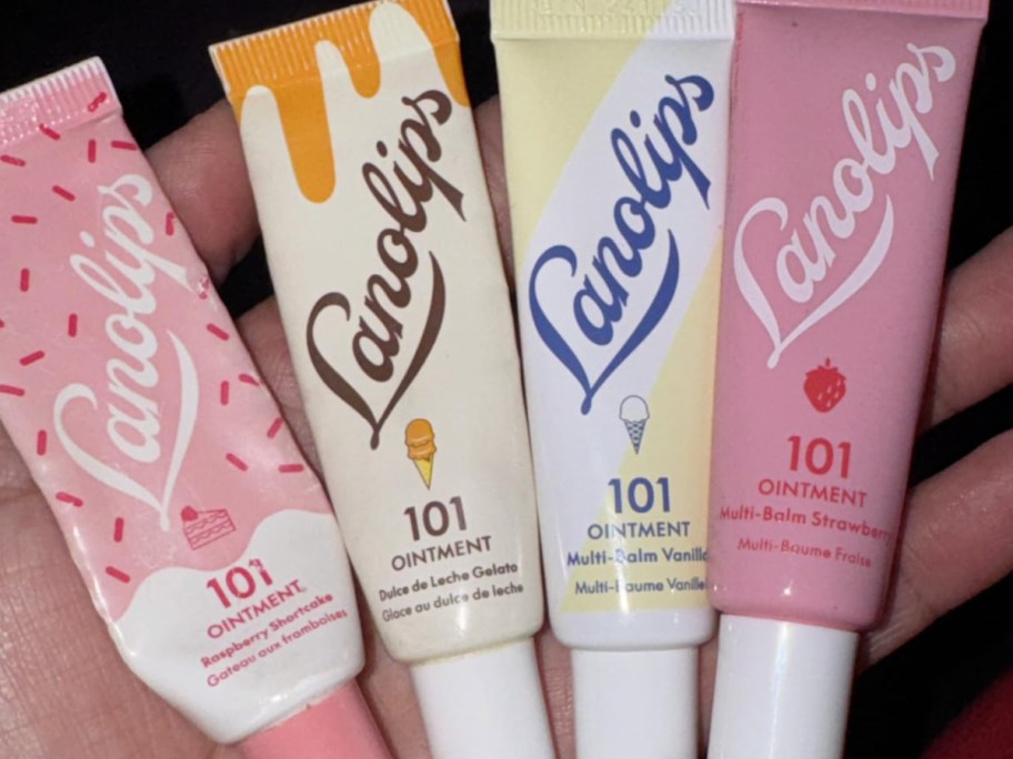 four tubes of lip balms in hand