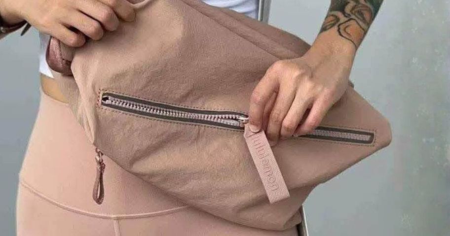 woman opening lululemon Fast Track Bag 2.0 10L