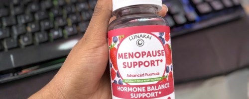 woman's hand holding a bottle of gummies