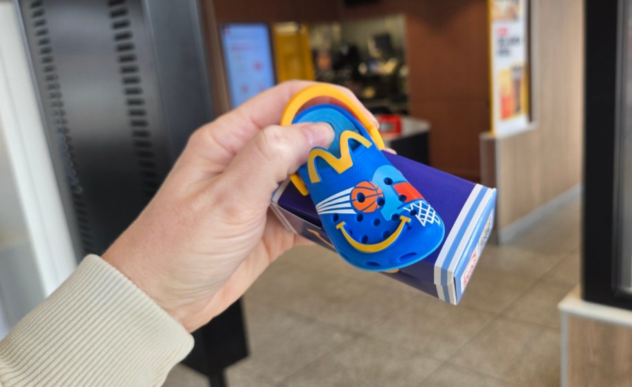 hand holding a blue toy croc from mcdonalds