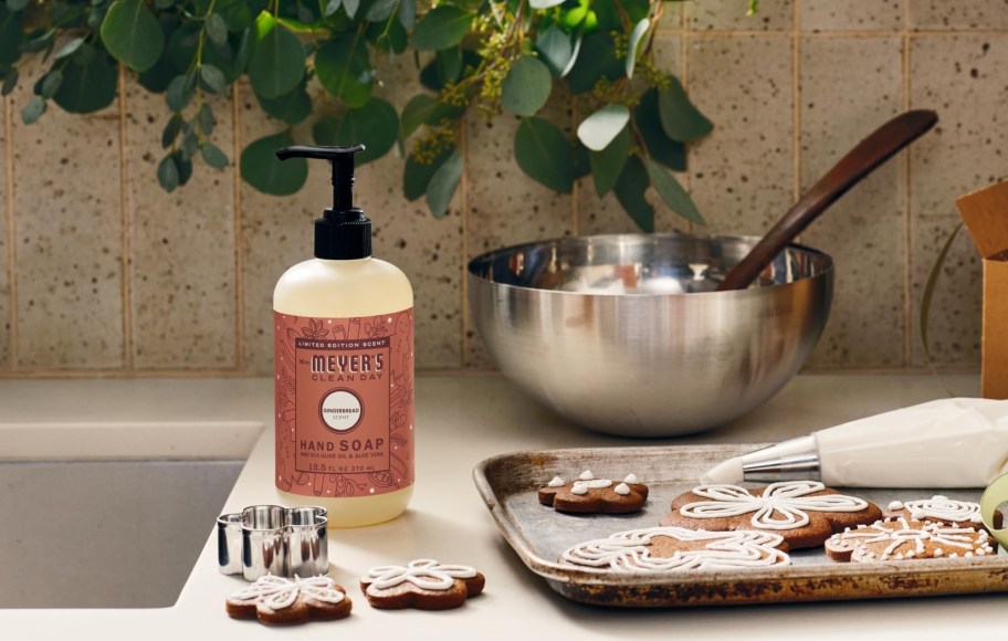 Mrs. Meyer's Gingerbread hand soap sitting on counter with gingerbread cookies and mixing bowl
