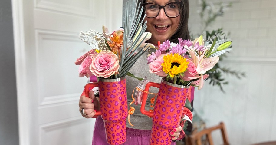 woman holding pink tumbler with flowers