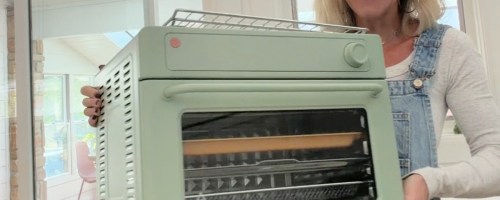 woman holding a mint green our place wonder oven