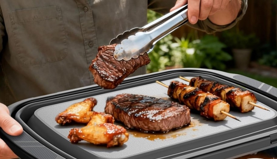 a man placing a steak onto a collapsed tray