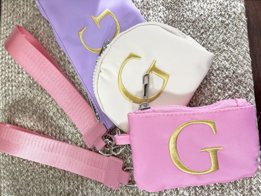 purple, white, and pink wristlet pouches with pink keychain straps