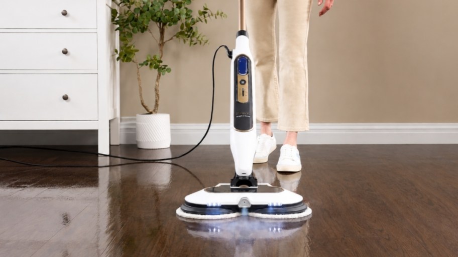 a woman using a shark steam mop