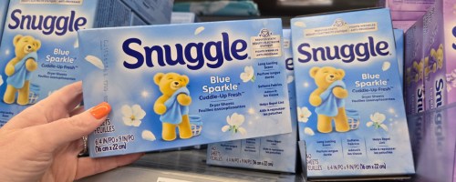 hand pulling a box of snuggle dryer sheets off a store shelf