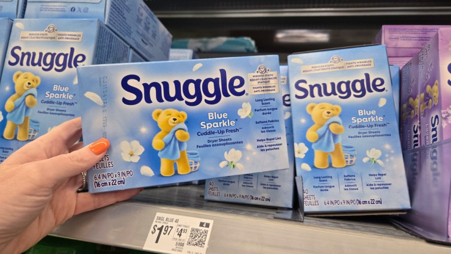 hand pulling a box of snuggle dryer sheets off a store shelf