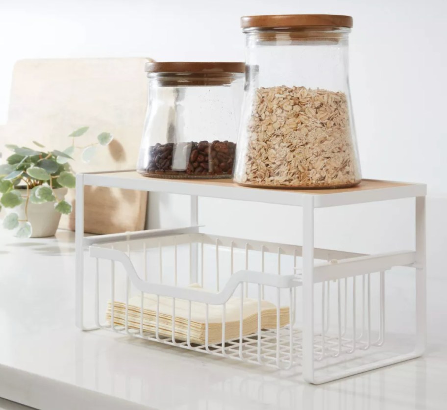 white wire organizer with two canisters on top