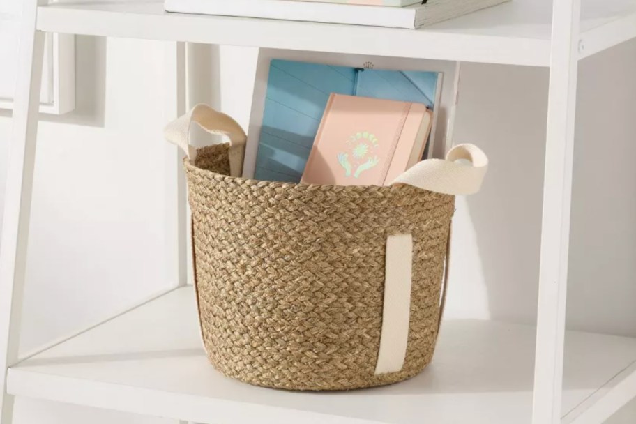 round basket with canvas handles holding books