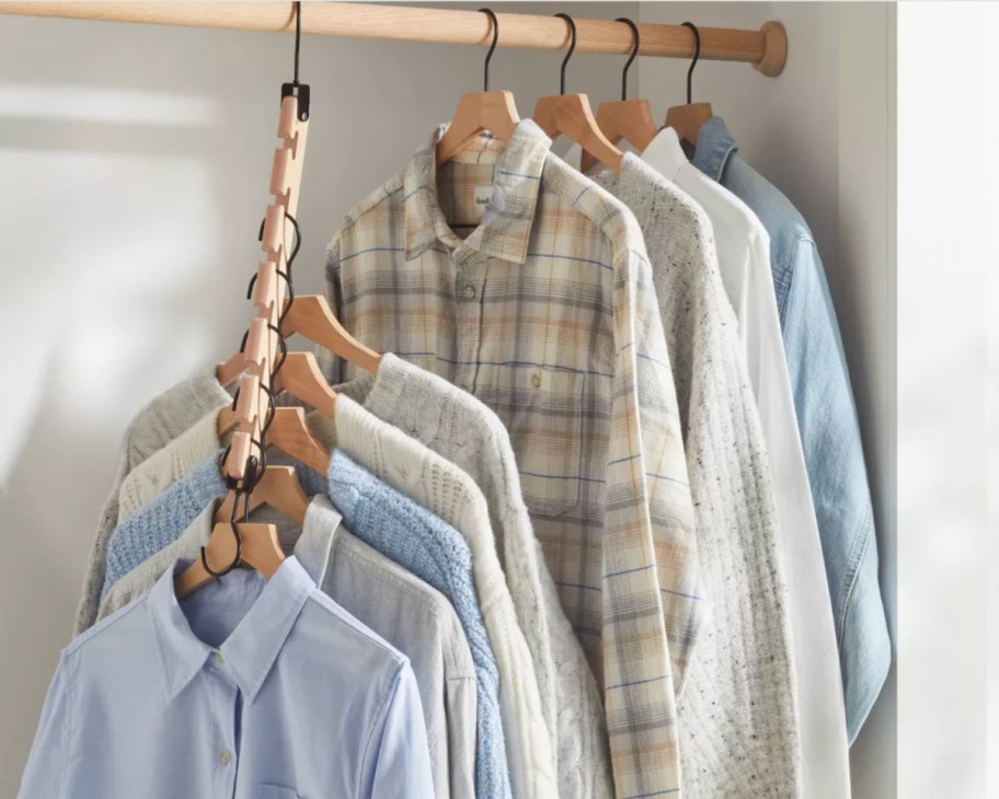 many button down shirts on single wooden hanger