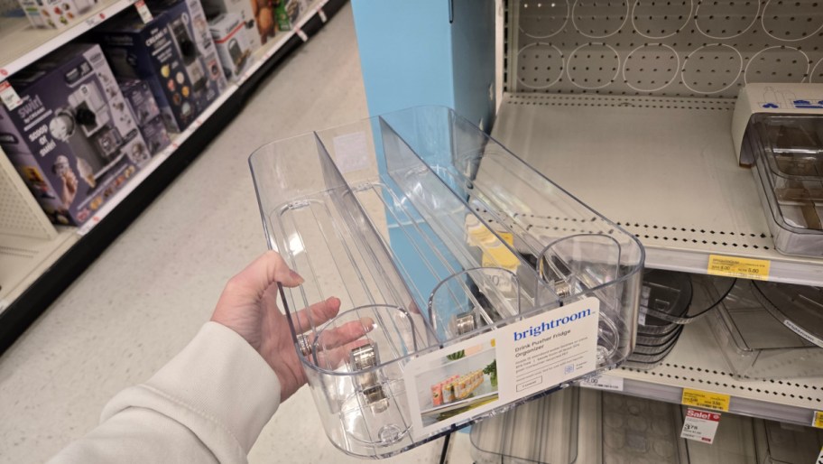 hand holding a clear plastic can dispenser fridge organizer