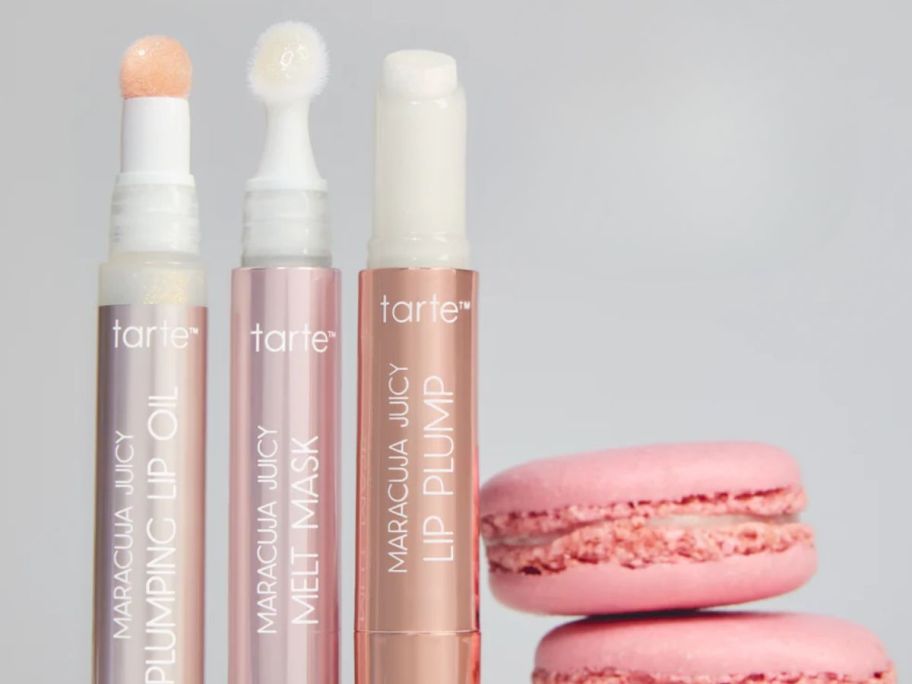 three tarte lip oils next to cookies