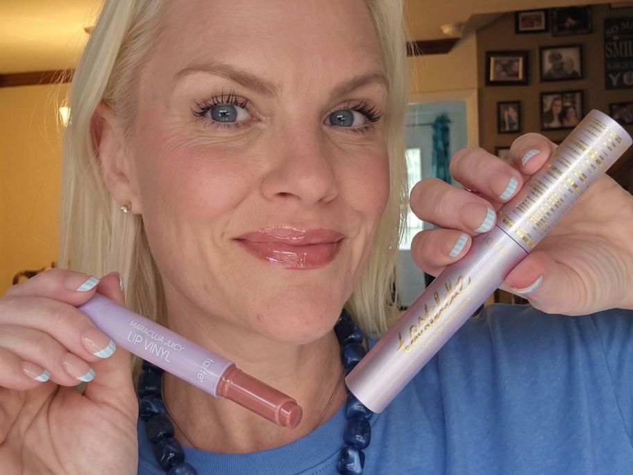 woman holding a tarte maracuja juicy lip vinyl and tartelette tubing mascara