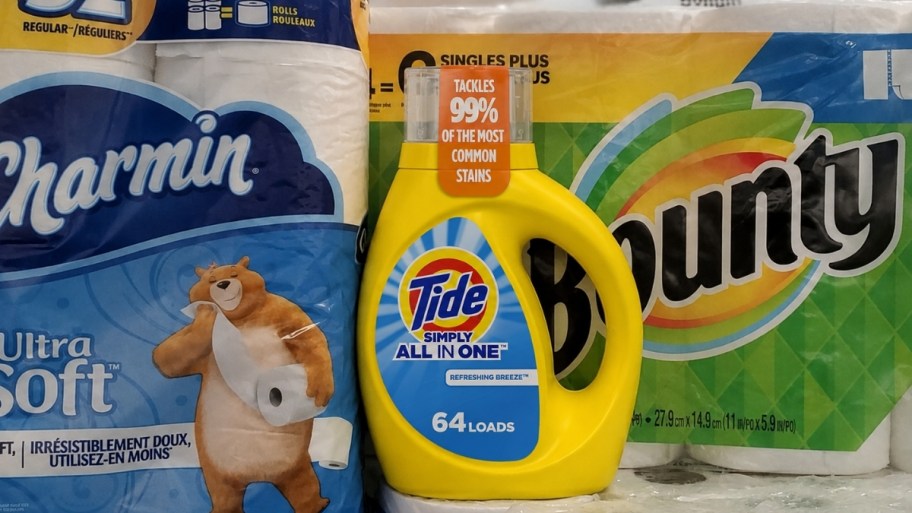 a bottle of tide liquid laundry det shown with paper towel and toilet paper packages