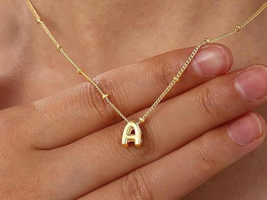 woman showing off initial necklace