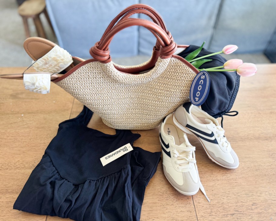 straw bag on table with sneakers and black dress