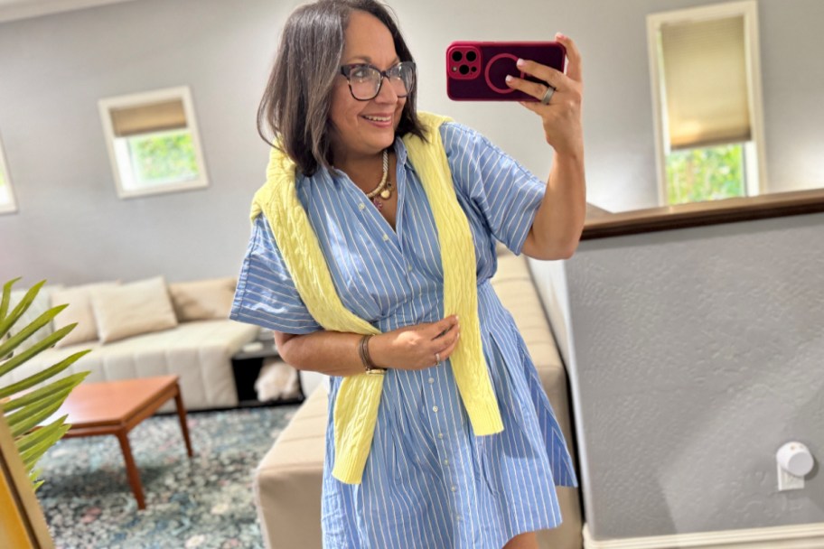 woman in blue dress with yellow cardigan taking selfie