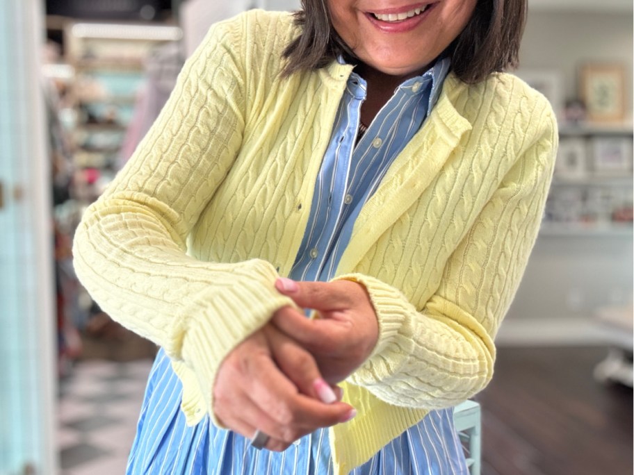 woman in yellow cable knit cardigan grabbing sleeve