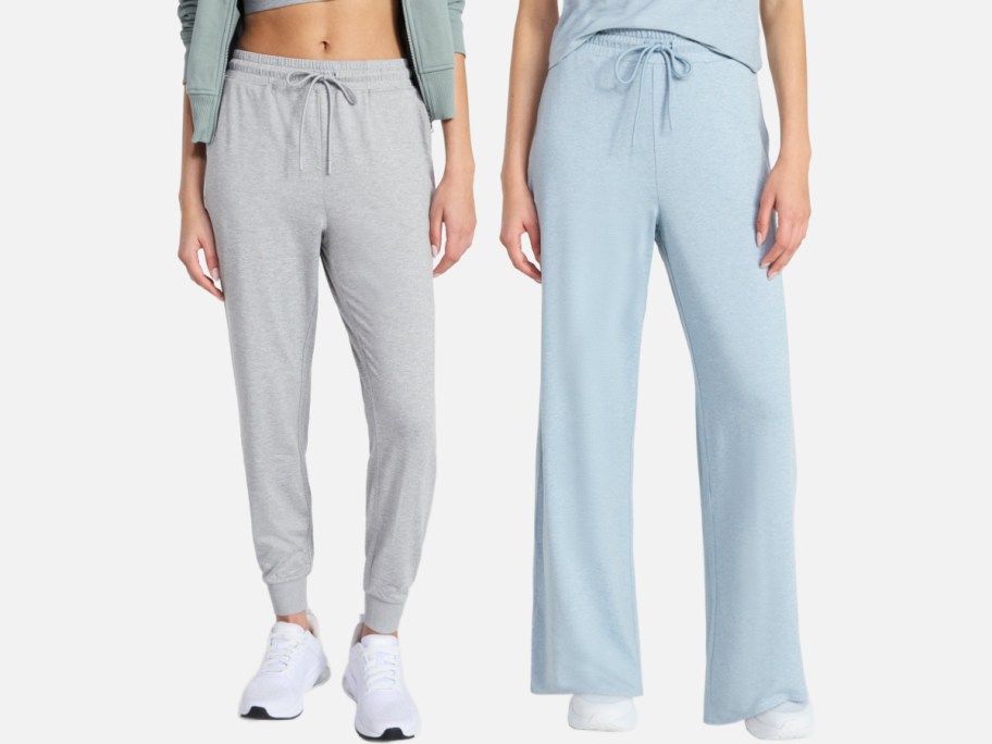 Two women are standing side by side and showing off casual pants. On the left, he wore gray jogging pants with ribbed sleeves, and on the right, he wore light blue wide-leg pants with drawstrings.
