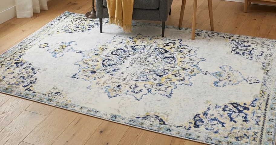 a cream, blue, tan, and gold area rug in a living room