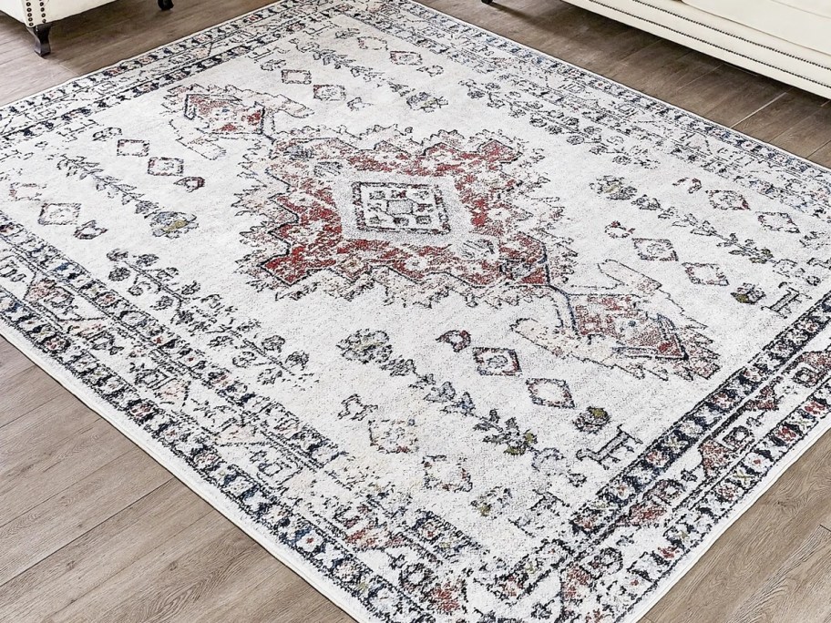 a red, cream, and grey oriental rug in a living room