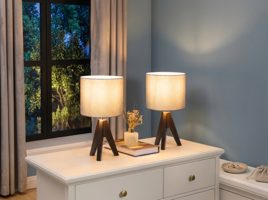 2 lamps with wooden bases on a table