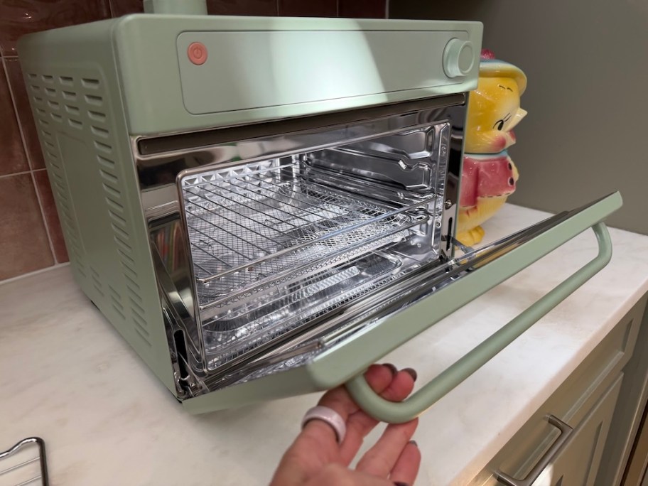 person opening Our Place Wonder Oven Pro on counter