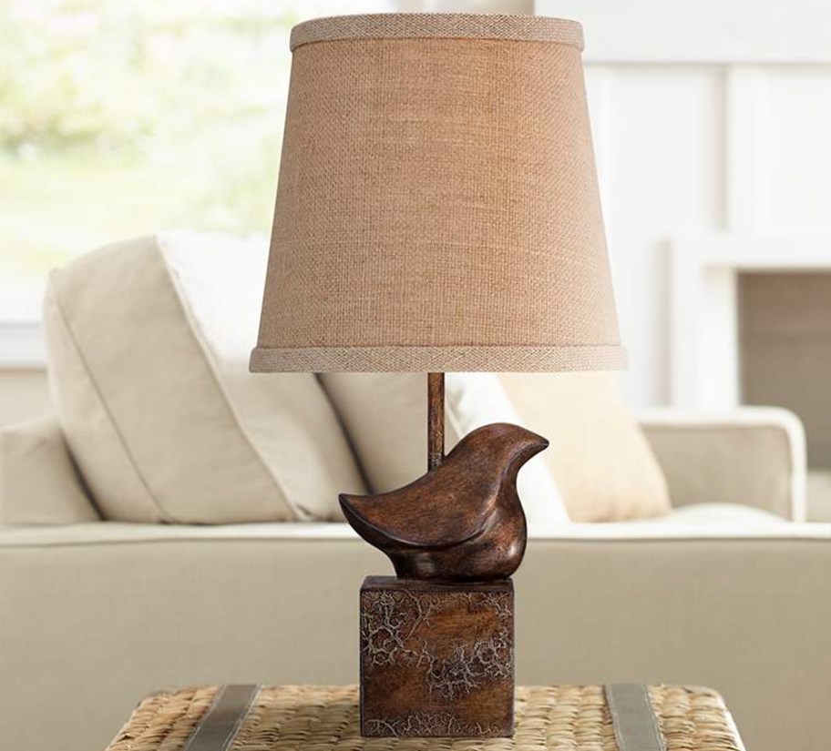 bronze bird lamp near sofa