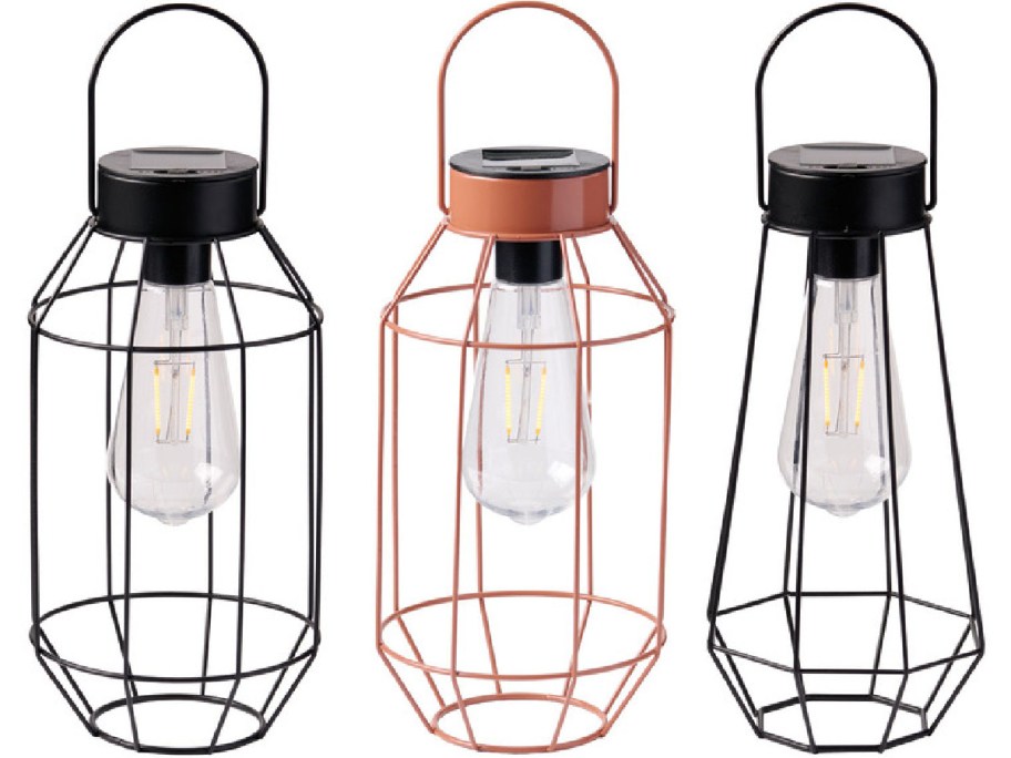 Three modern solar lanterns with black and copper wire frames. Each holds a vintage-style bulb.
