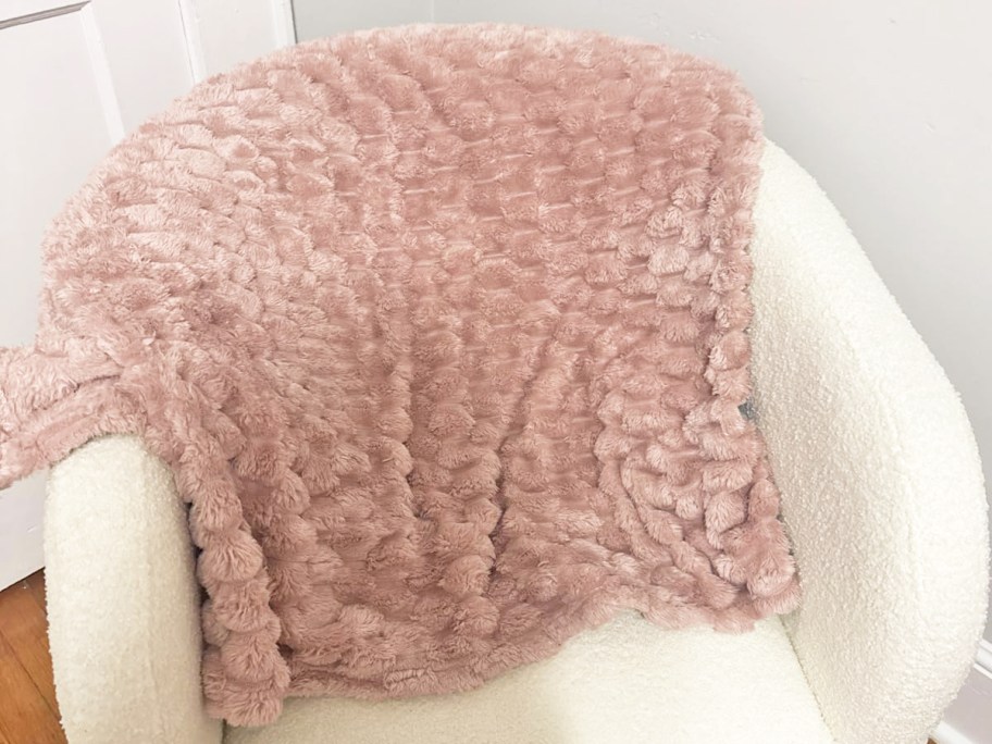 pink throw blanket over a white chair