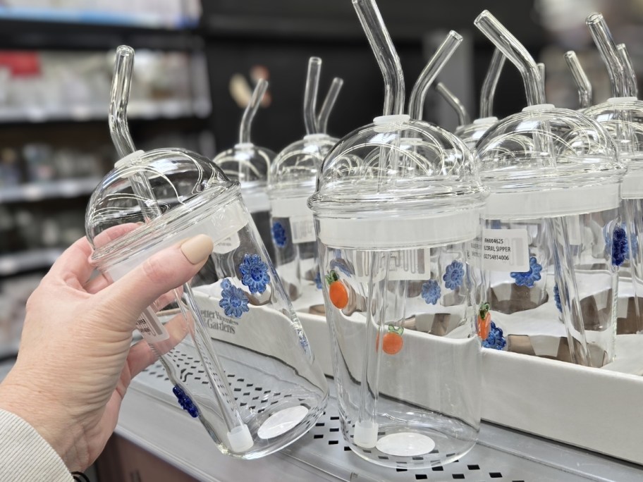 better homes & gardens glass sipper cups with flower and orange icons and a dome shaped lid on store shelf