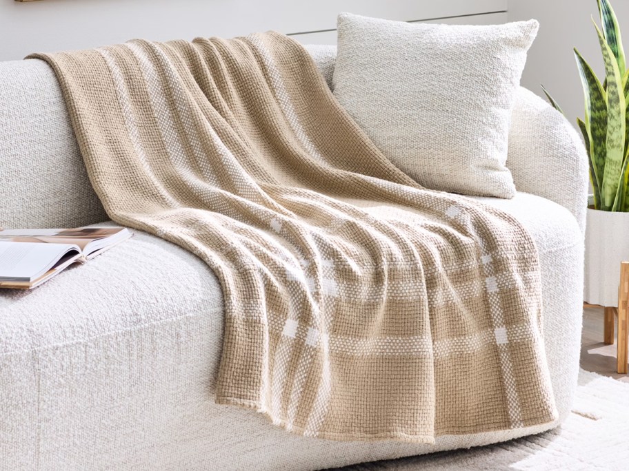 tan plaid blanket draped over a sofa